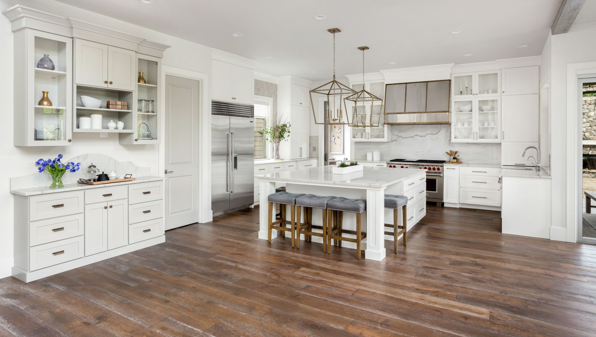 Bright white kitchen with wide-plank hardwood flooring